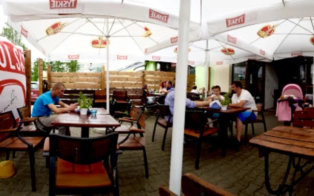 Ogródek letni Pizzerii Tabia – stoliki pod parasolami